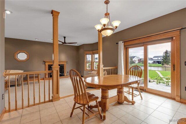 dining space featuring ornate columns, baseboards, ceiling fan, and light tile patterned floors