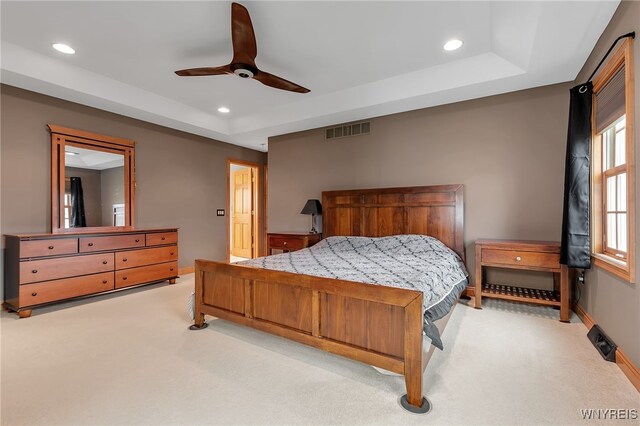 bedroom with visible vents, recessed lighting, a raised ceiling, and light colored carpet