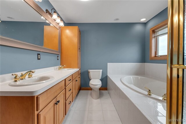 full bath with toilet, tile patterned floors, a sink, and a garden tub