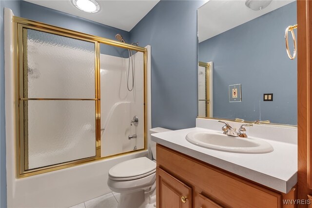 bathroom with toilet, tile patterned floors, combined bath / shower with glass door, and vanity