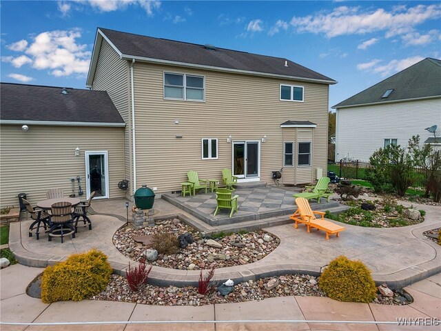 rear view of property with fence and a patio area