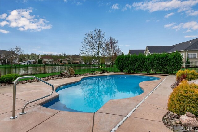 view of swimming pool featuring a residential view, a fenced in pool, a fenced backyard, and a patio