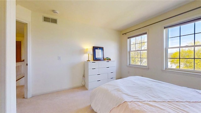 carpeted bedroom with visible vents and baseboards