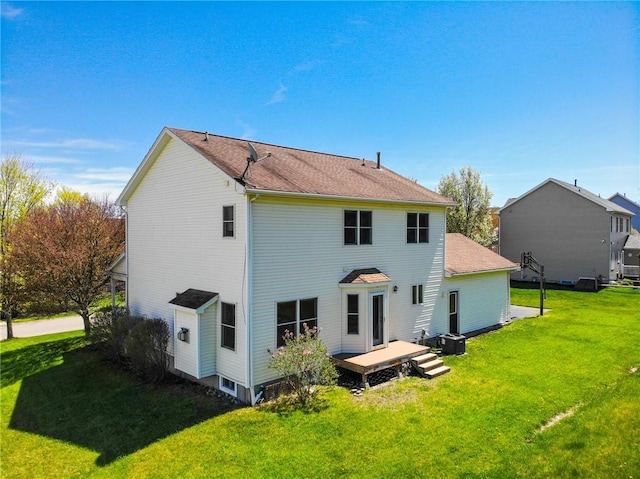 rear view of property with a yard, a deck, and central AC