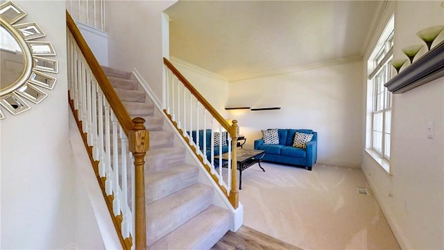 stairway featuring baseboards and ornamental molding