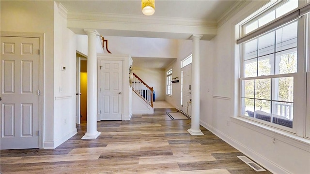 entryway featuring visible vents, crown molding, stairs, baseboards, and ornate columns