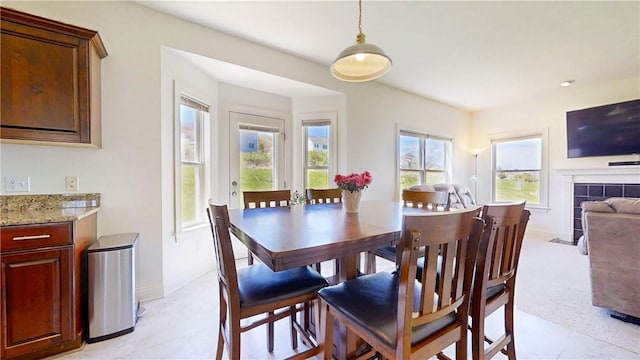 dining space with baseboards, plenty of natural light, and a fireplace