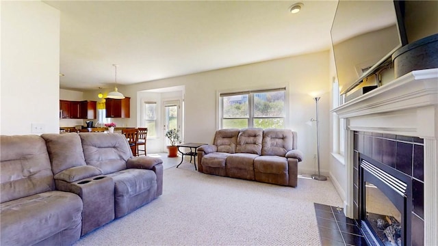 living room featuring a tiled fireplace and dark carpet