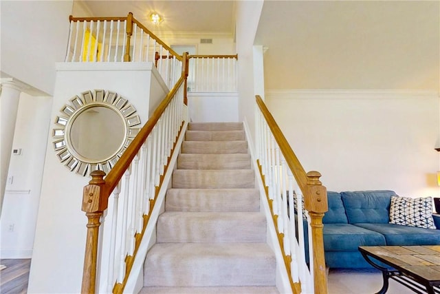 stairs with baseboards and crown molding