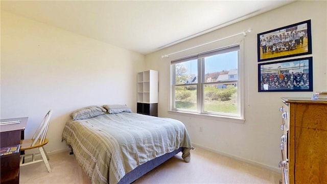 bedroom with baseboards and light colored carpet