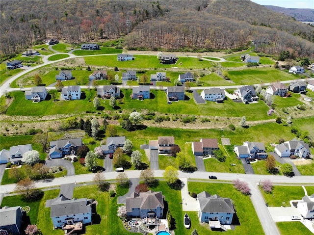 drone / aerial view featuring a view of trees and a residential view