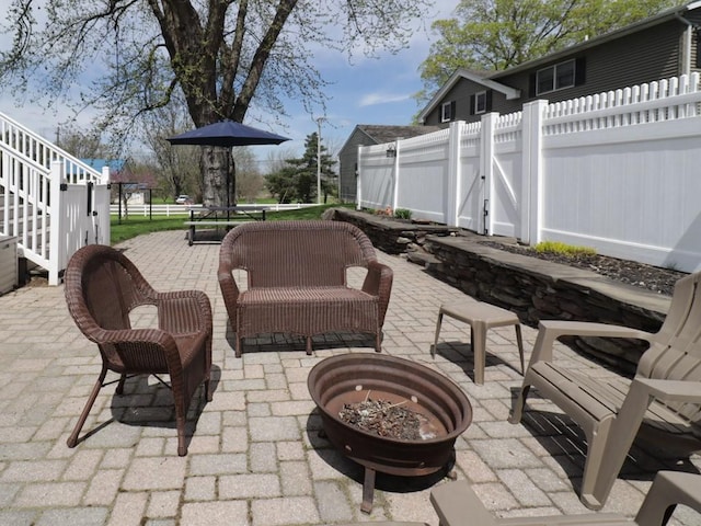 view of patio / terrace featuring a gate, a fire pit, and fence