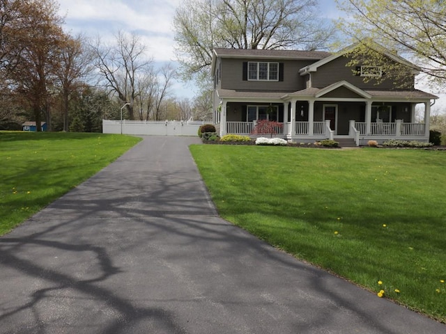 view of front facade with fence, a gate, a porch, and a front yard