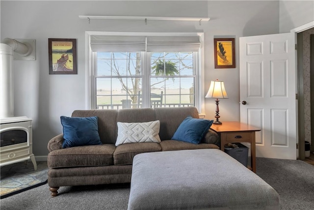 carpeted living room featuring a wood stove