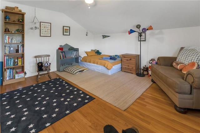 bedroom with vaulted ceiling and wood finished floors