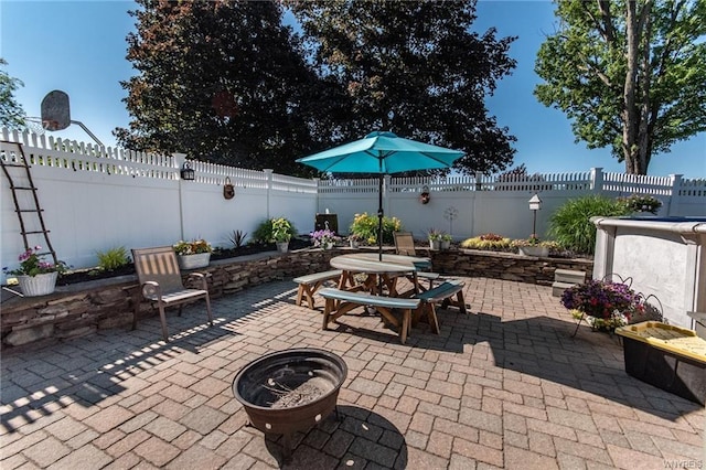 view of patio featuring outdoor dining area, a fenced backyard, and an outdoor fire pit