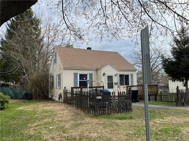 rear view of property with a lawn, a shingled roof, fence, and a deck
