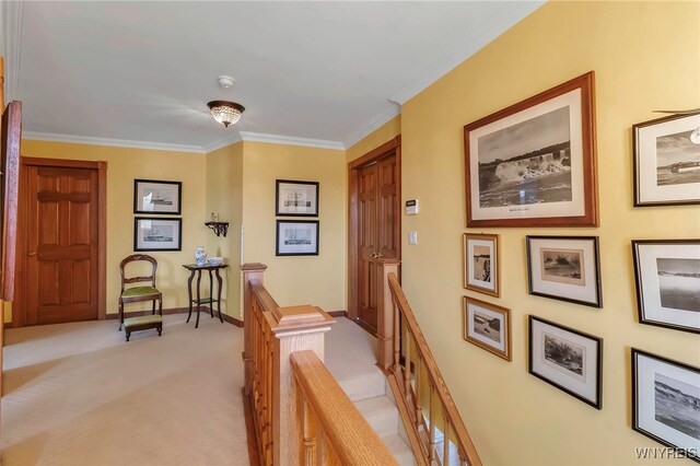 corridor featuring crown molding, baseboards, an upstairs landing, and light carpet