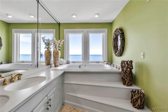 full bathroom featuring vanity, tile patterned floors, a bath, and a healthy amount of sunlight
