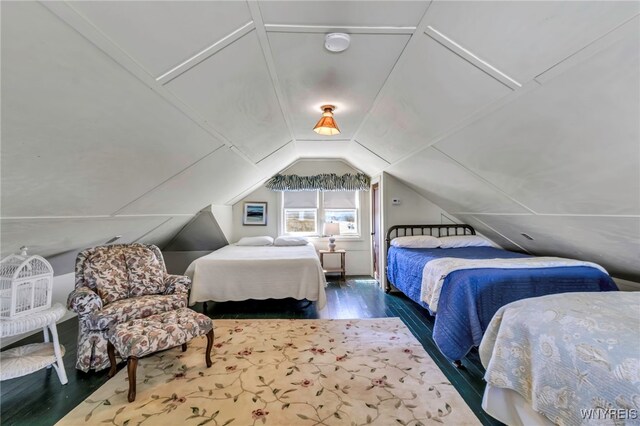 bedroom with lofted ceiling and wood finished floors