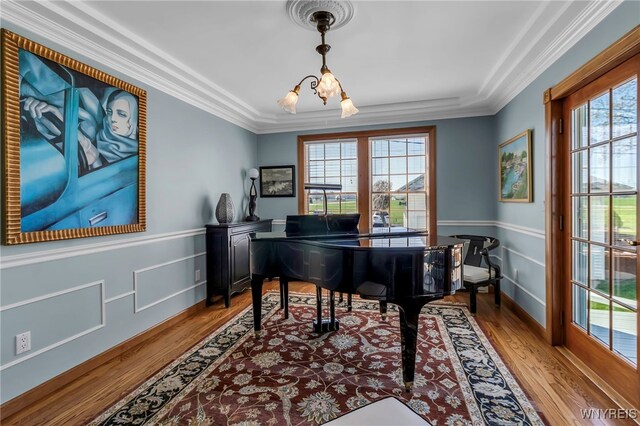sitting room with wood finished floors, a chandelier, and a healthy amount of sunlight