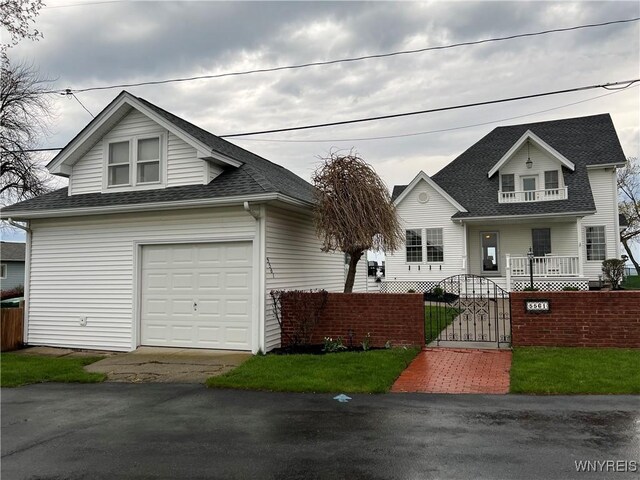 view of front of property with a gate, a shingled roof, a porch, a fenced front yard, and driveway