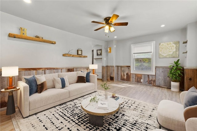 living room with wainscoting, wood finished floors, ceiling fan, wooden walls, and recessed lighting