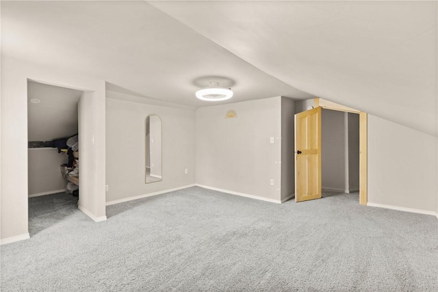 additional living space with baseboards and carpet flooring