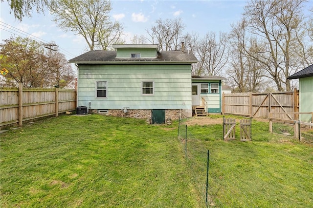 back of house featuring a lawn, a chimney, a fenced backyard, and entry steps