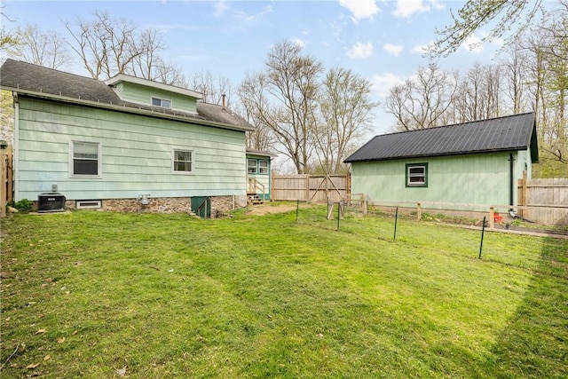 view of yard with a fenced backyard and central AC unit