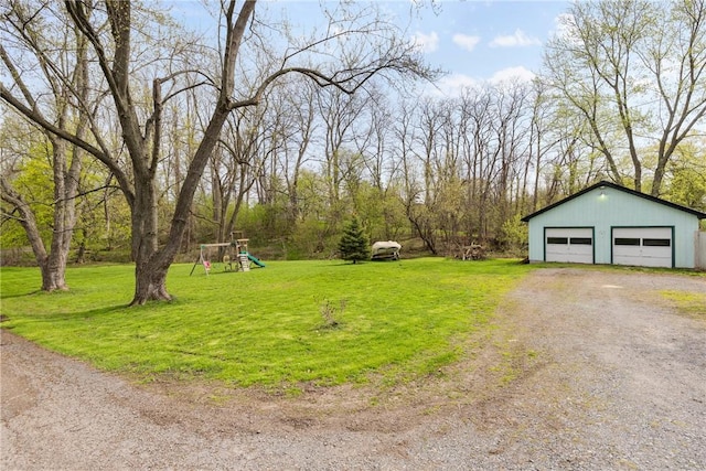 view of yard featuring a playground, an outbuilding, and a garage