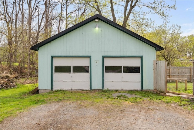 detached garage featuring fence