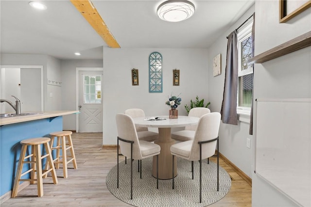 dining space featuring a healthy amount of sunlight, recessed lighting, light wood-type flooring, and beam ceiling