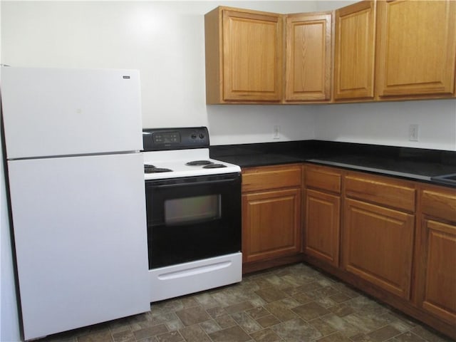 57-59 Maple St, Oneonta-City, NY 13820 - kitchen featuring brown cabinetry, freestanding refrigerator, electric range oven, and dark countertops
