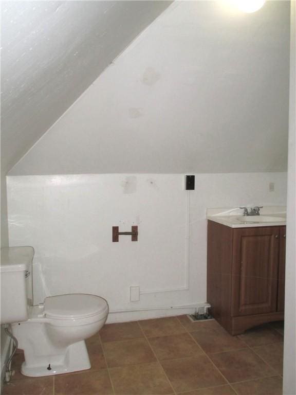 57-59 Maple St, Oneonta-City, NY 13820 - bathroom with toilet, vaulted ceiling, tile patterned flooring, and vanity