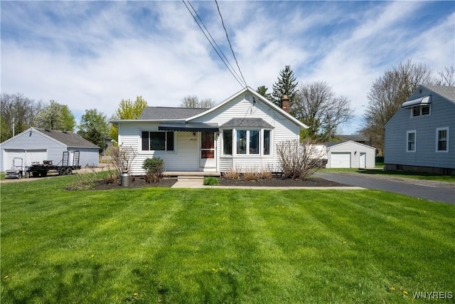 view of front of house with an outdoor structure, a chimney, a front yard, and a detached garage