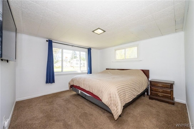 carpeted bedroom featuring baseboards and multiple windows