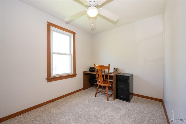 home office with baseboards, ceiling fan, and light carpet