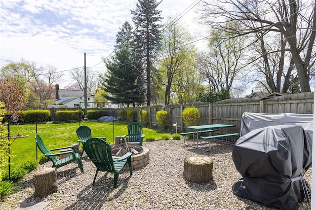 view of yard featuring a fenced backyard and a fire pit