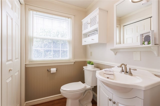 half bath featuring toilet, wainscoting, ornamental molding, and vanity
