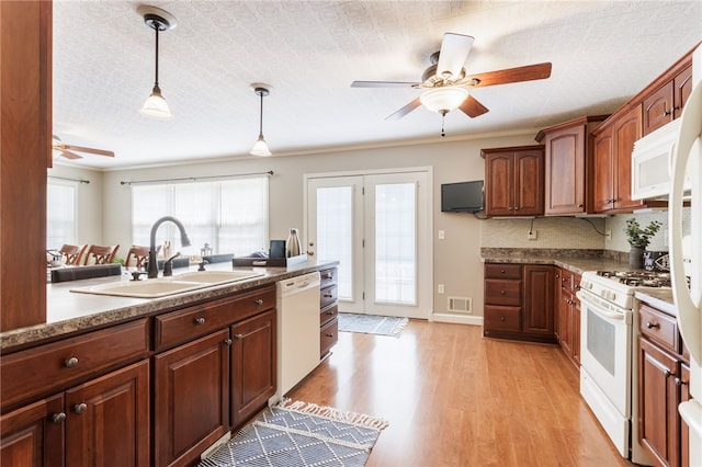 kitchen featuring a ceiling fan, visible vents, hanging light fixtures, a sink, and white appliances