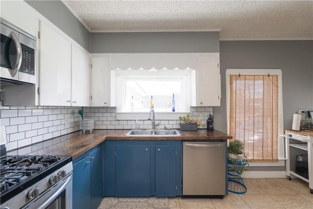 9 Porter St, Prattsburgh, NY 14873 - kitchen with butcher block countertops, blue cabinets, tasteful backsplash, a sink, and appliances with stainless steel finishes