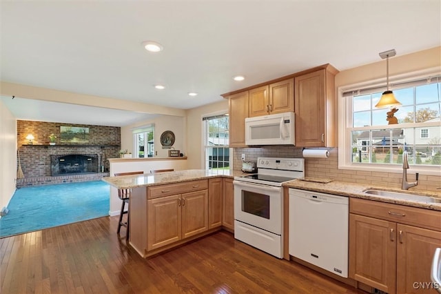 4765 Rosemary Ln, Clay, NY 13088 - kitchen with a fireplace, dark wood finished floors, a sink, a peninsula, and white appliances
