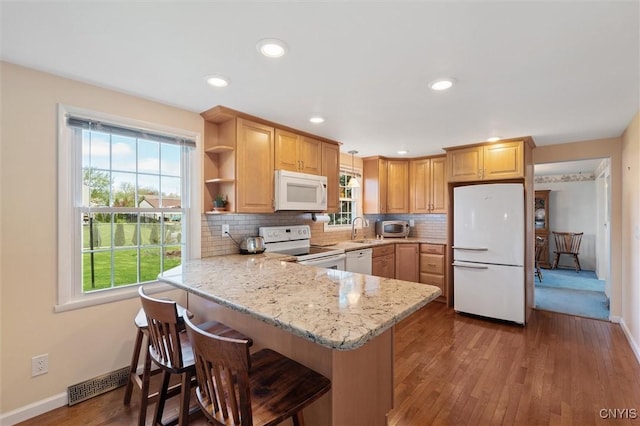 4765 Rosemary Ln, Clay, NY 13088 - kitchen with a healthy amount of sunlight, a sink, a peninsula, white appliances, and hardwood / wood-style floors