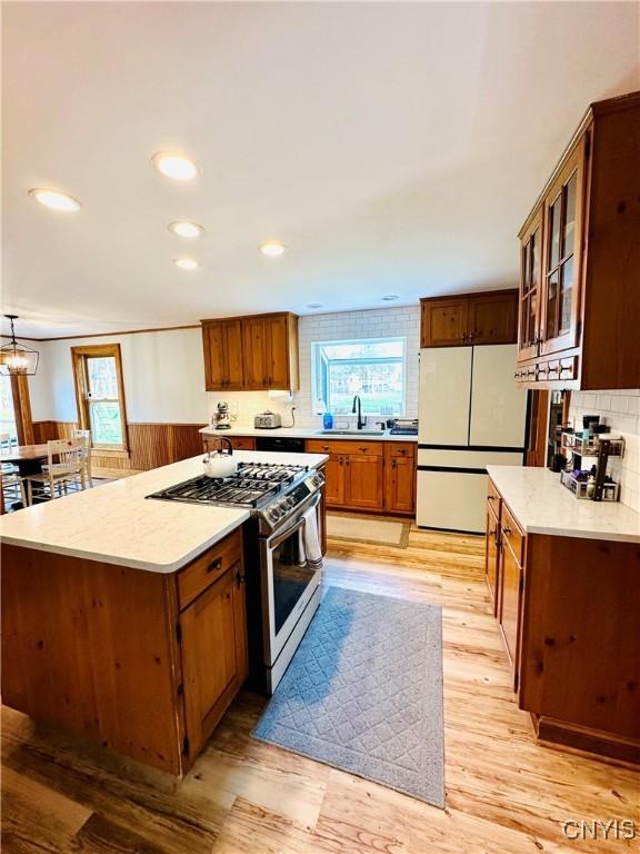 1058 State Route 48, Granby, NY 13069 - kitchen with plenty of natural light, freestanding refrigerator, wainscoting, and stainless steel gas stove