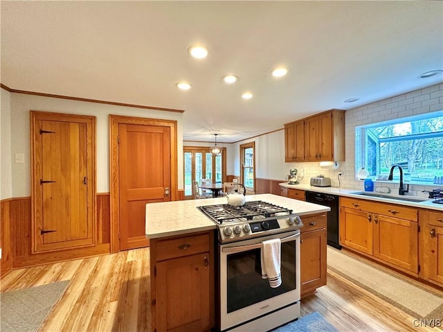 1058 State Route 48, Granby, NY 13069 - kitchen featuring wainscoting, light wood-style floors, stainless steel range with gas cooktop, a sink, and dishwasher