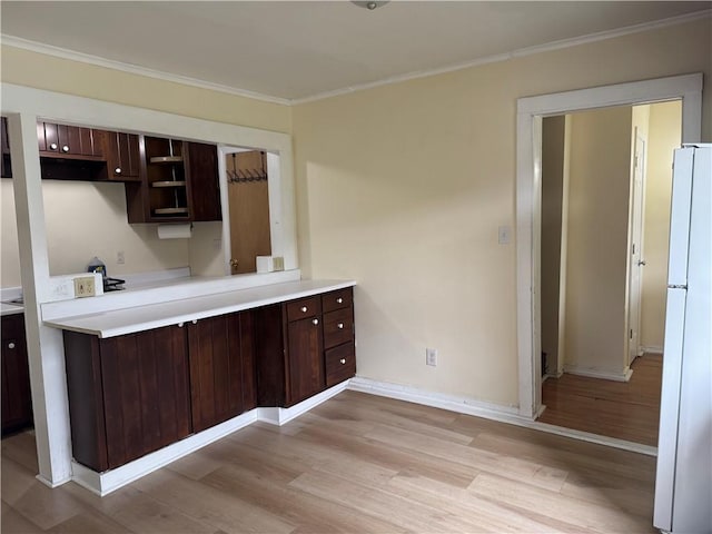 2129 State Highway 206, Masonville, NY 13849 - kitchen featuring dark brown cabinetry, light countertops, freestanding refrigerator, ornamental molding, and light wood-style flooring