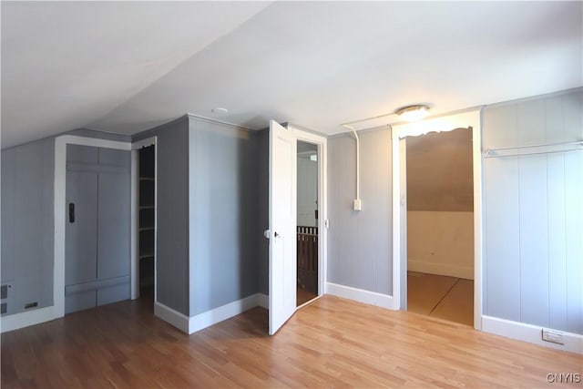 bonus room featuring wood finished floors, baseboards, and lofted ceiling