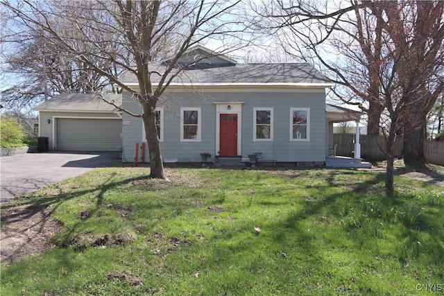 view of front facade featuring fence, an attached garage, a front yard, and aphalt driveway