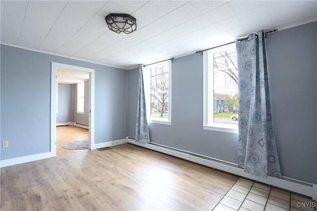 unfurnished room with crown molding, baseboard heating, baseboards, and wood finished floors